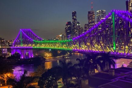 Story Bridge lit in purple and green